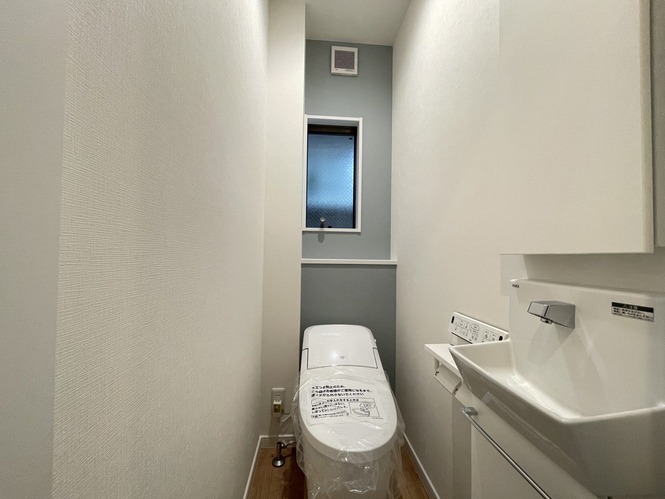 １階トイレ。ロータンクタイプのトイレと独立型手洗い器は、お掃除がしやすく清潔に保つことができます。